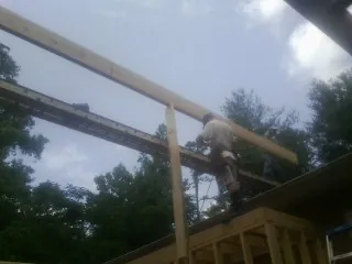 Carpenter setting a ridge beam over a new addition frame — Ice Dam Removal by Roofing Brothers in Canyon Creek