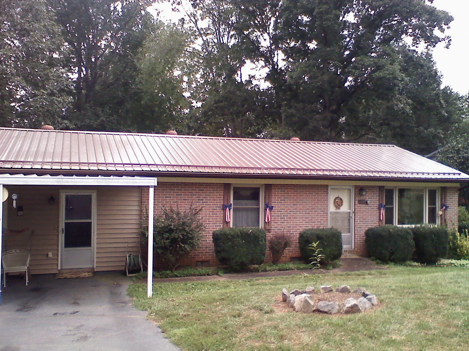 Bronze metal roof and carport on a brick ranch home — Roof Repair work by our crew in Canyon Creek